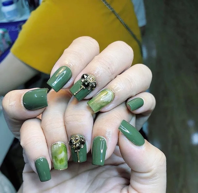 Mẫu nail màu xanh rêu đính đá giúp nàng tỏa sáng trong mọi ánh nhìn