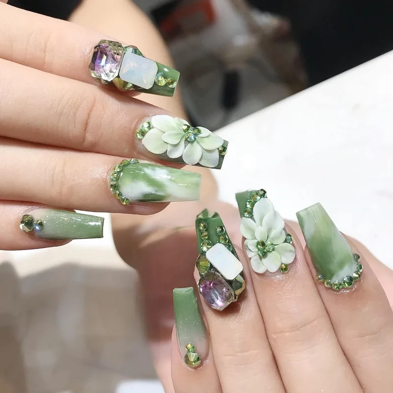 Nail màu xanh rêu đính đá giúp đôi tay thêm phần nổi bật